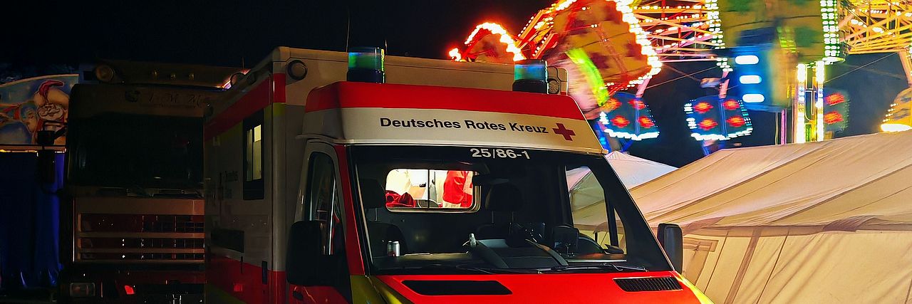 Fotografie des RTW  und Sanitätszelt vor einen Karussell, Festbeleuchtung des Schützenfest Betzdorf 2025
