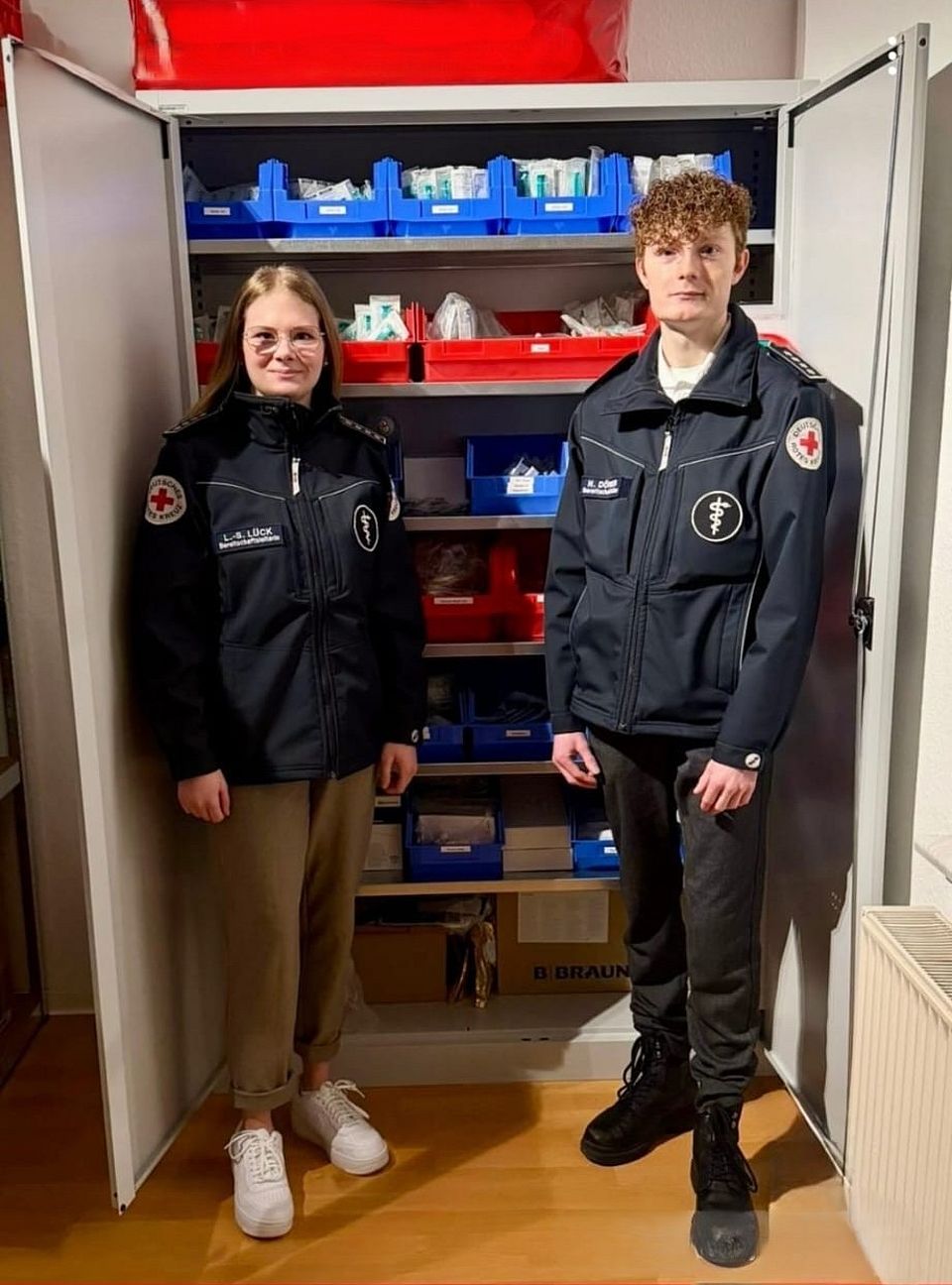 Bereitschaftsleiterin Lara Sophie Lück und Bereitschaftsleiter Niklas Dörner informieren über neuen Materialschrank
