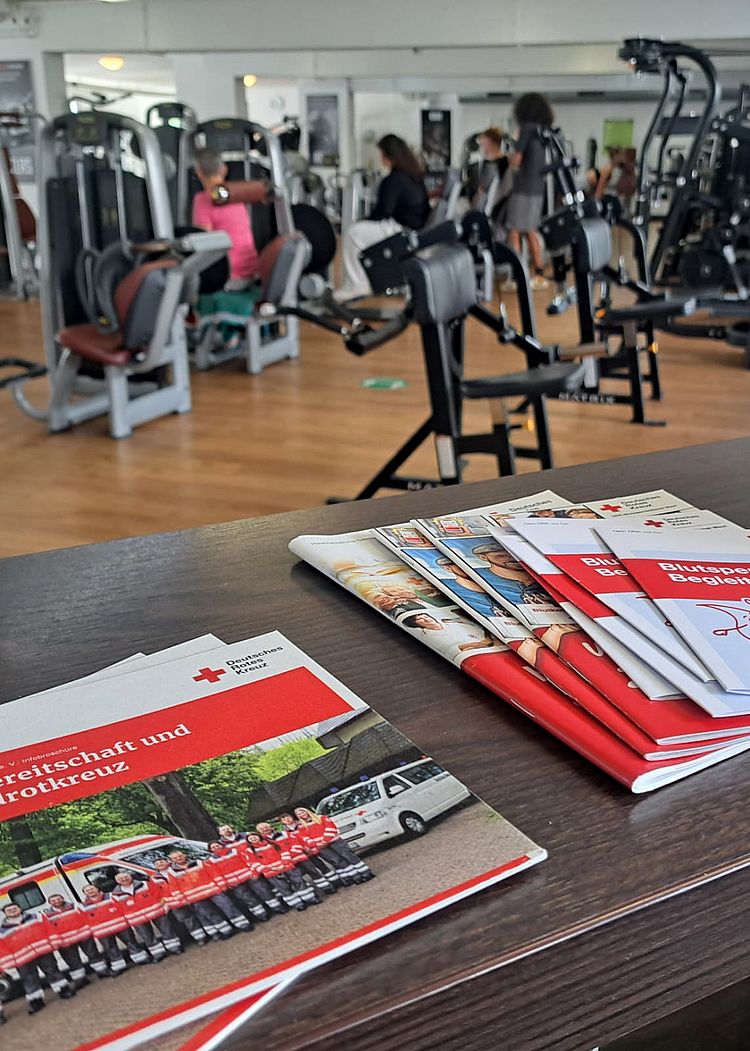 Flyer der Blutspende auf dem Tresen des Atlas Sport Betzdorf, im Hintergrund Sportgeräte