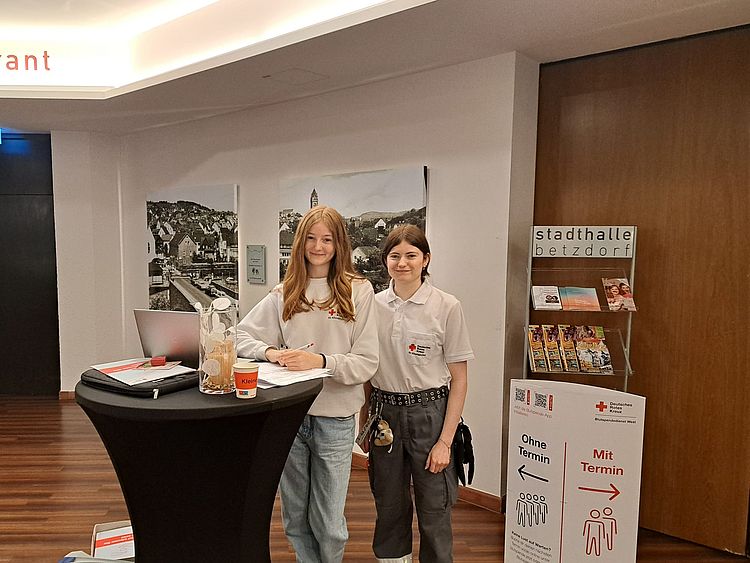 Zwei Helferinnen, eingesetzt als Blutspendelotsen, bei der Begrüßung der Spender.